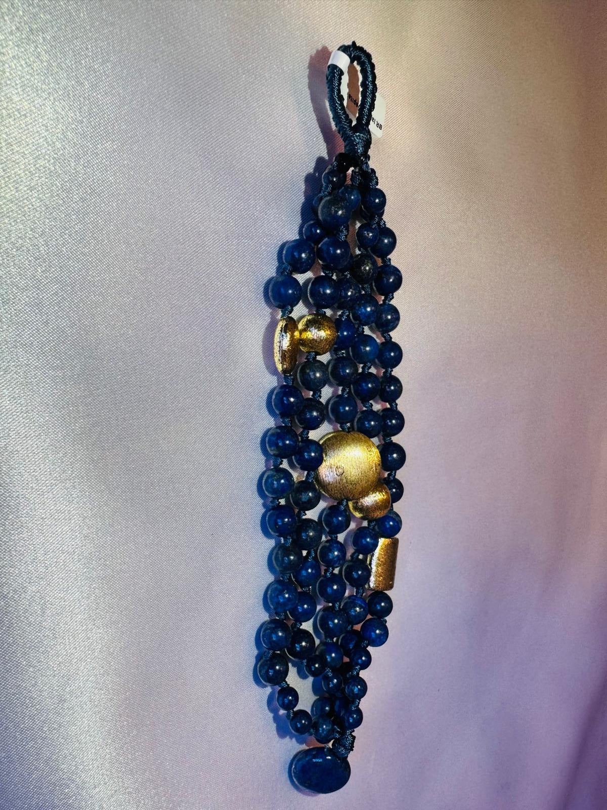 Multi strand lapis lazuli and nugget bracelet with a golden centerpiece