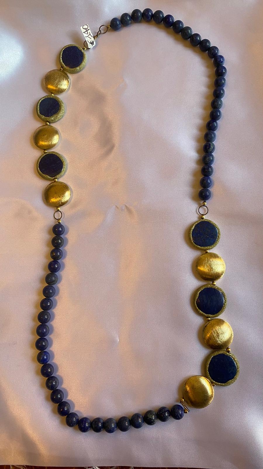 Lapis lazuli and nugget Necklace with blue beads and gold circular accents.